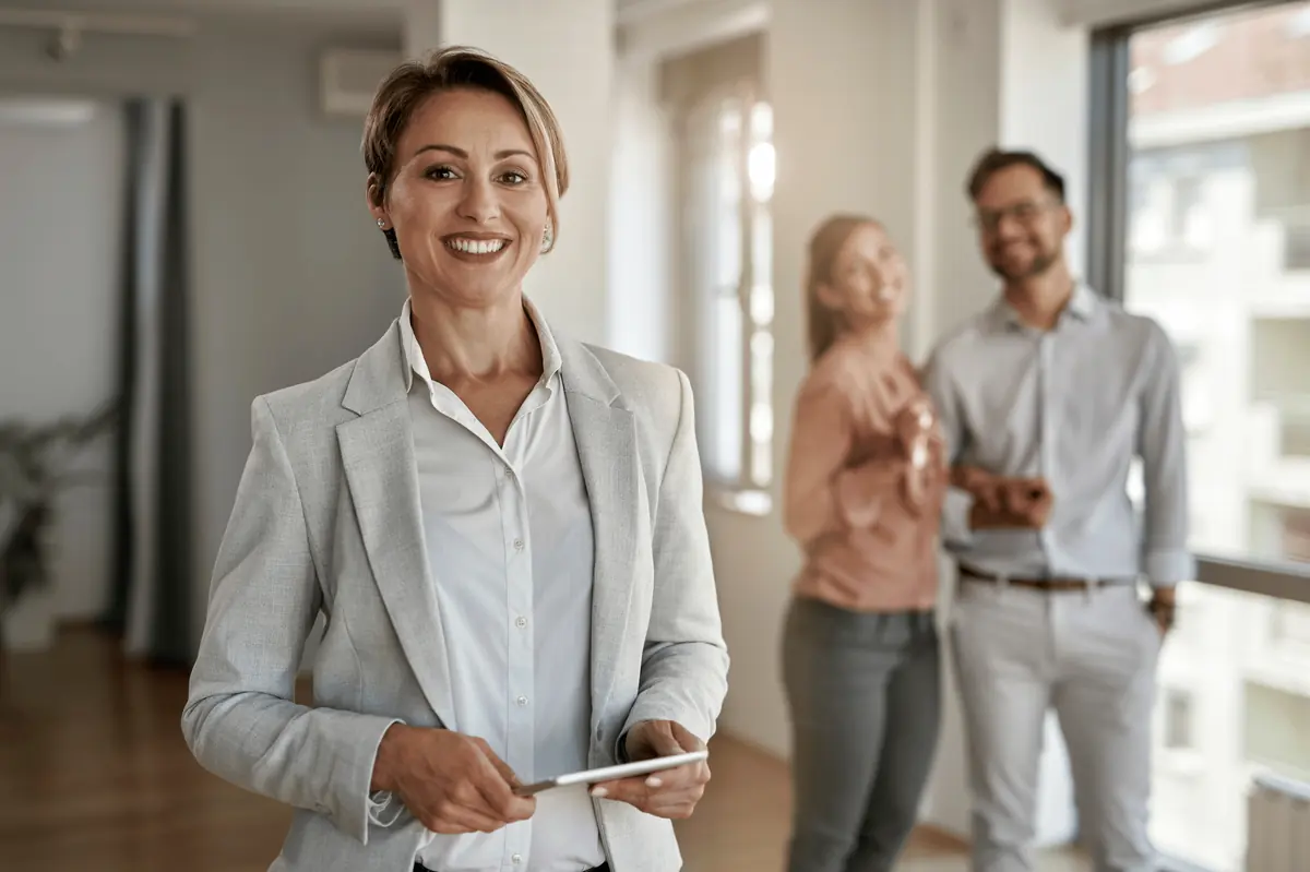 Smiling real estate agent holding a tablet